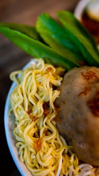 Close-up of a flavorful Indonesian noodle bowl with meatballs, ideal for Asian cuisine enthusiasts.