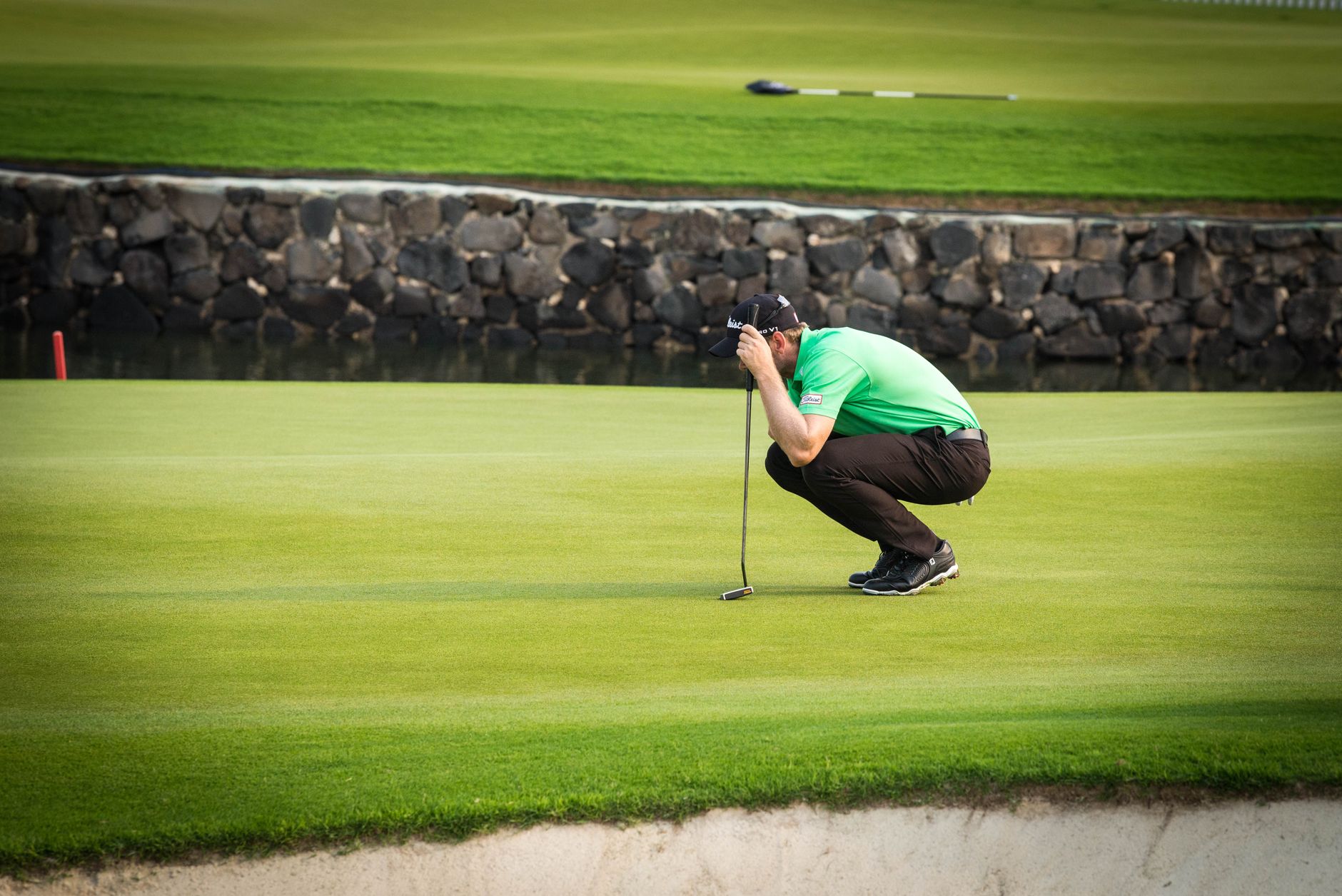 A golfer studying tournament odds beside a leaderboard, cloudy fairway and detailed notebook visible