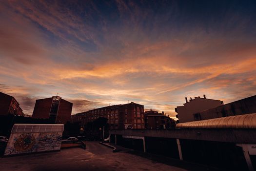 Beautiful sunset scene over urban buildings with a dramatic sky.