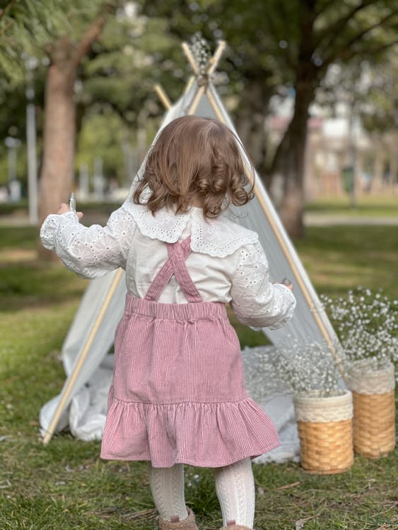 Back View of a Cute Little Girl Running on the Grass 