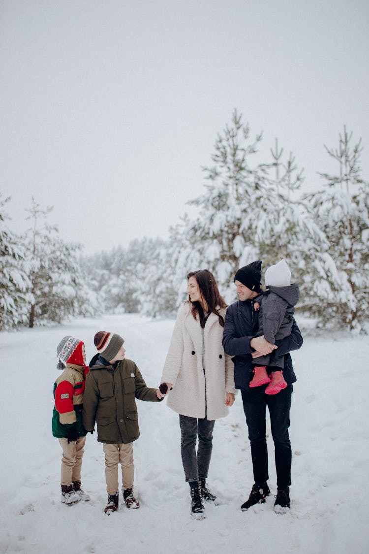 Family With Three Kids Standing Outdoors In Winter 