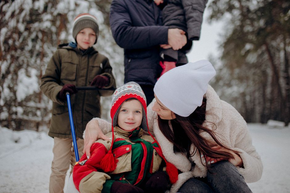 Family enjoying winter together in a snowy forest, bonding and playing.