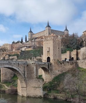 A stunning view of Alcázar and Alcántara Bridge in Toledo, Spain, showcasing medieval architecture.