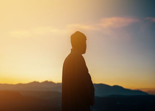 Free Silhouette of a man standing in the mountains at sunset, capturing the warm hues of Srinagar's landscape. Stock Photo