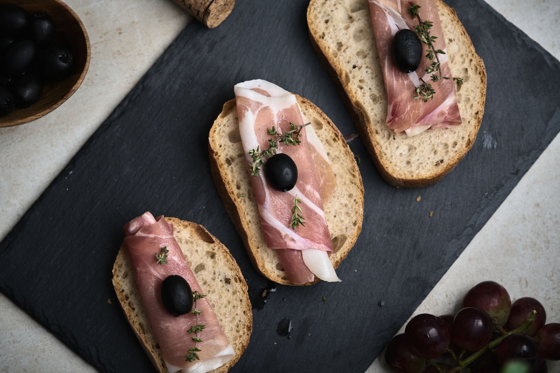 Top View of Bread Slices with Ham and Black Olive on Top
