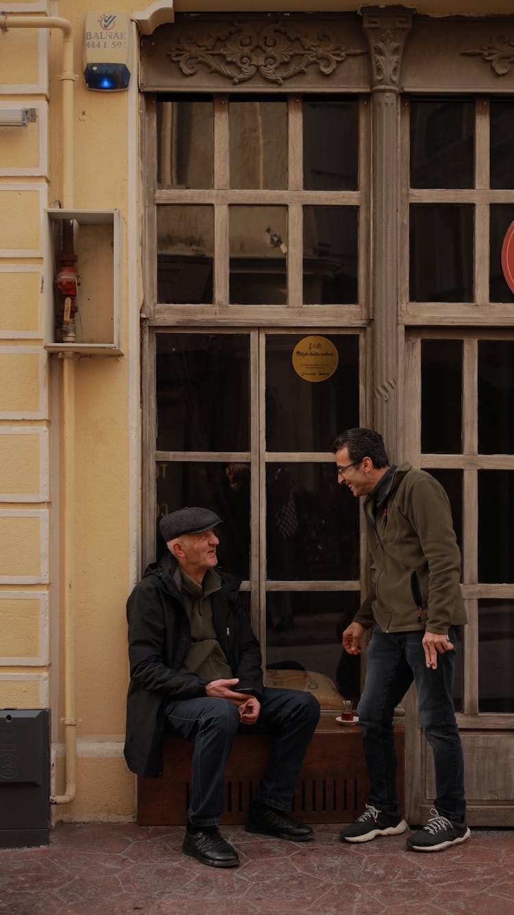 Man Talking Near Building Windows