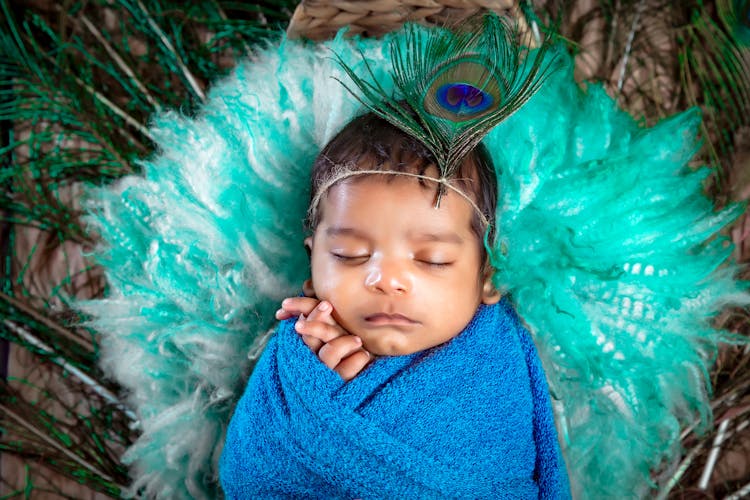 Cute Baby Sleeping On Peacock Feathers