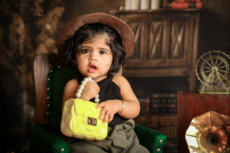 Portrait Of A Cute Baby Holding A Purse