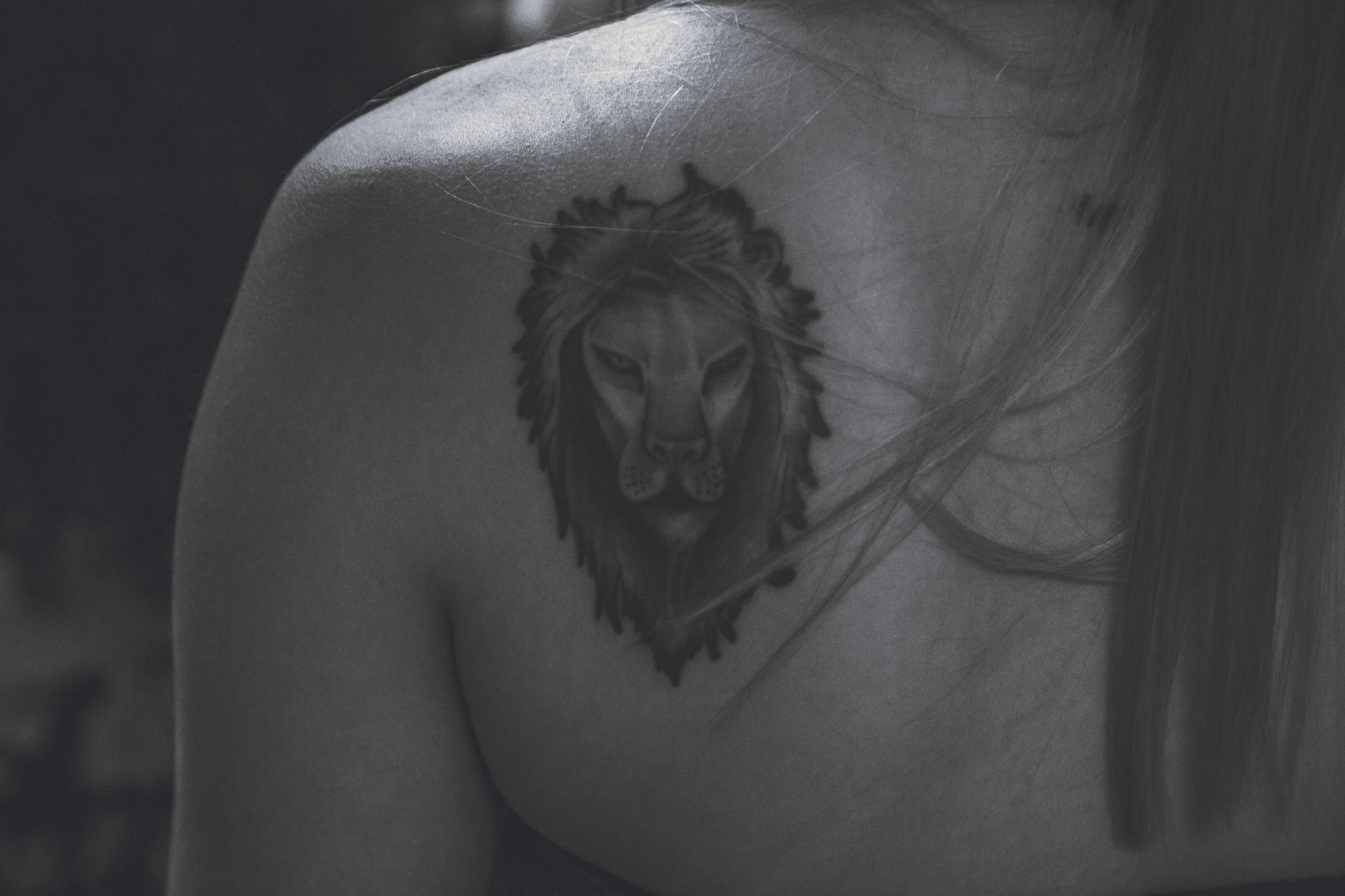 Black and white close-up of a detailed temporary tattoo on the shoulder blade