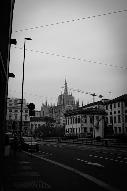 Black and White Photo of a Street by the Palazzo del Capitano di Giustizia and with View of the Milan Cathedral in the Background 