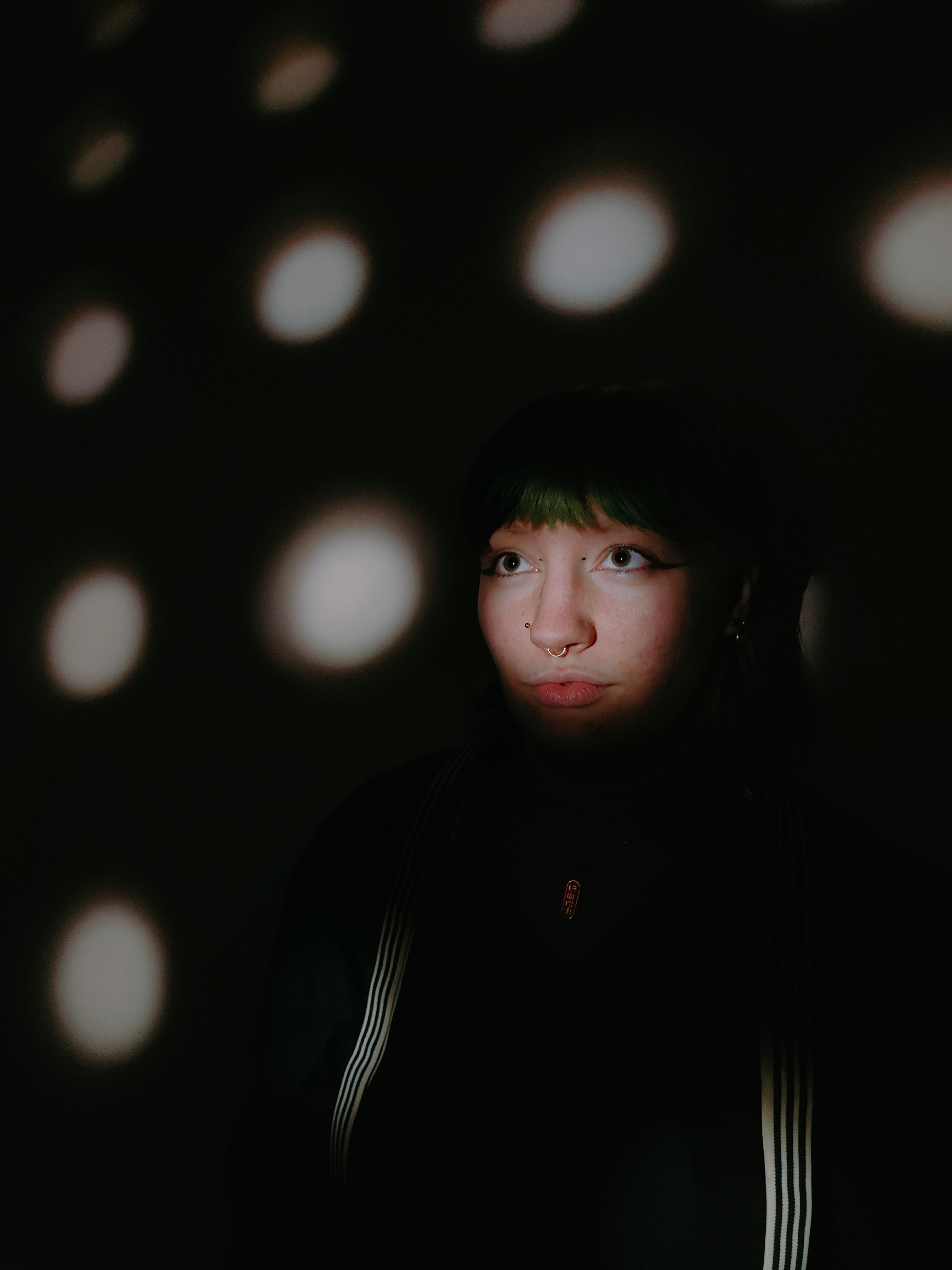 Face of a Young Woman Standing in a Dark Room · Free Stock Photo