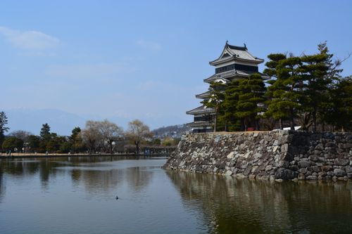 Free Scenic view of historic Matsumoto Castle by a serene lake surrounded by nature. Stock Photo