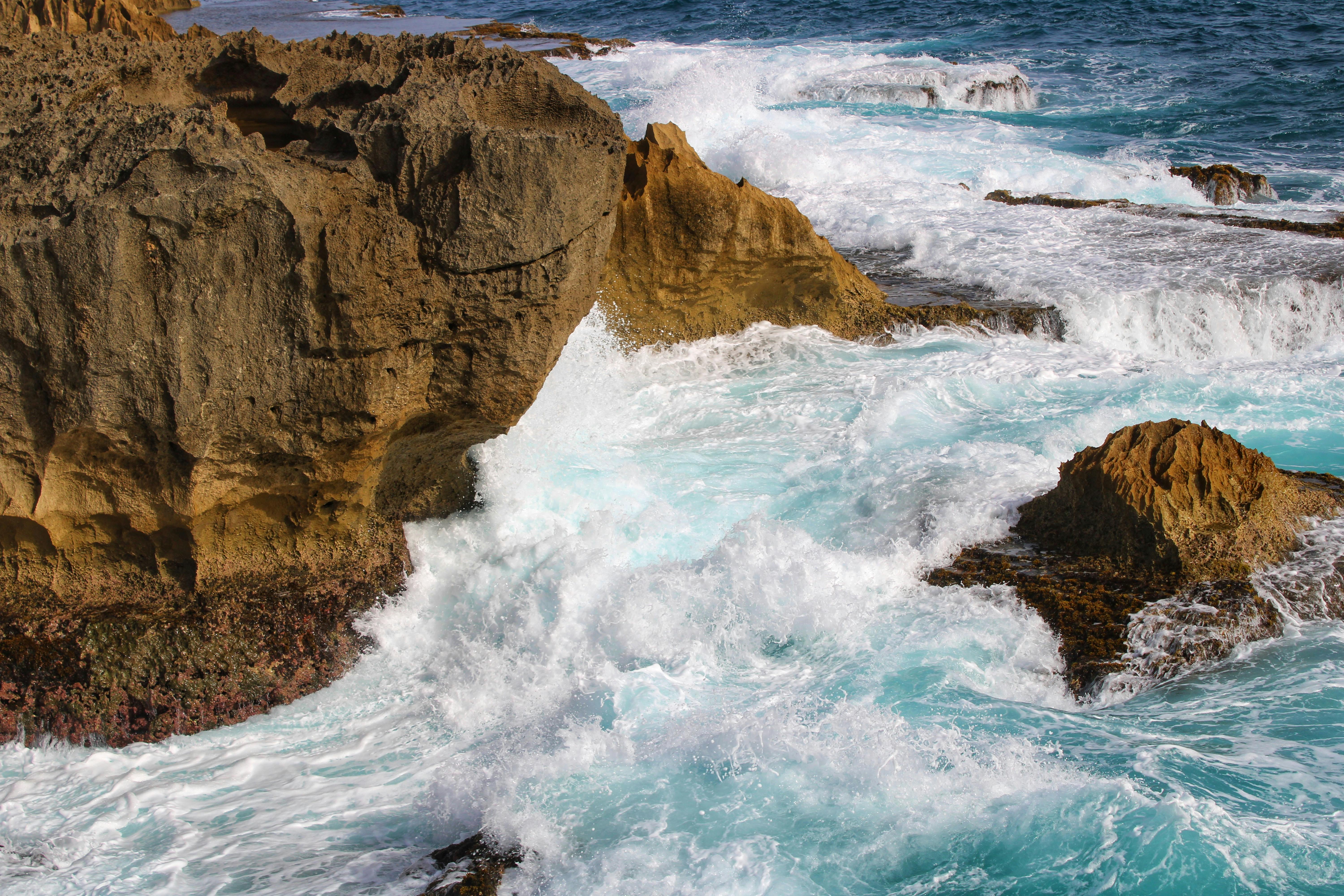 A rocky shore with waves crashing into the rocks · Free Stock Photo