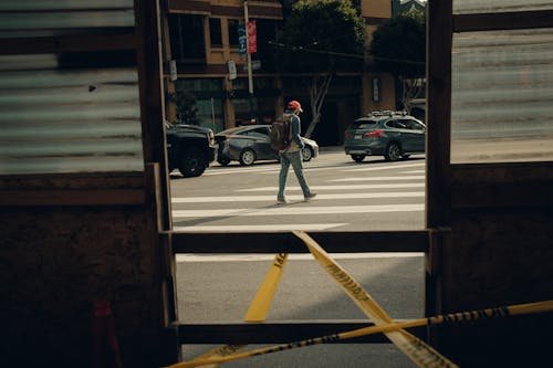 Free A man walking across a street with a yellow tape Stock Photo