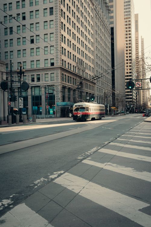 Free Vintage tram on a quiet street surrounded by skyscrapers in a modern urban landscape. Stock Photo