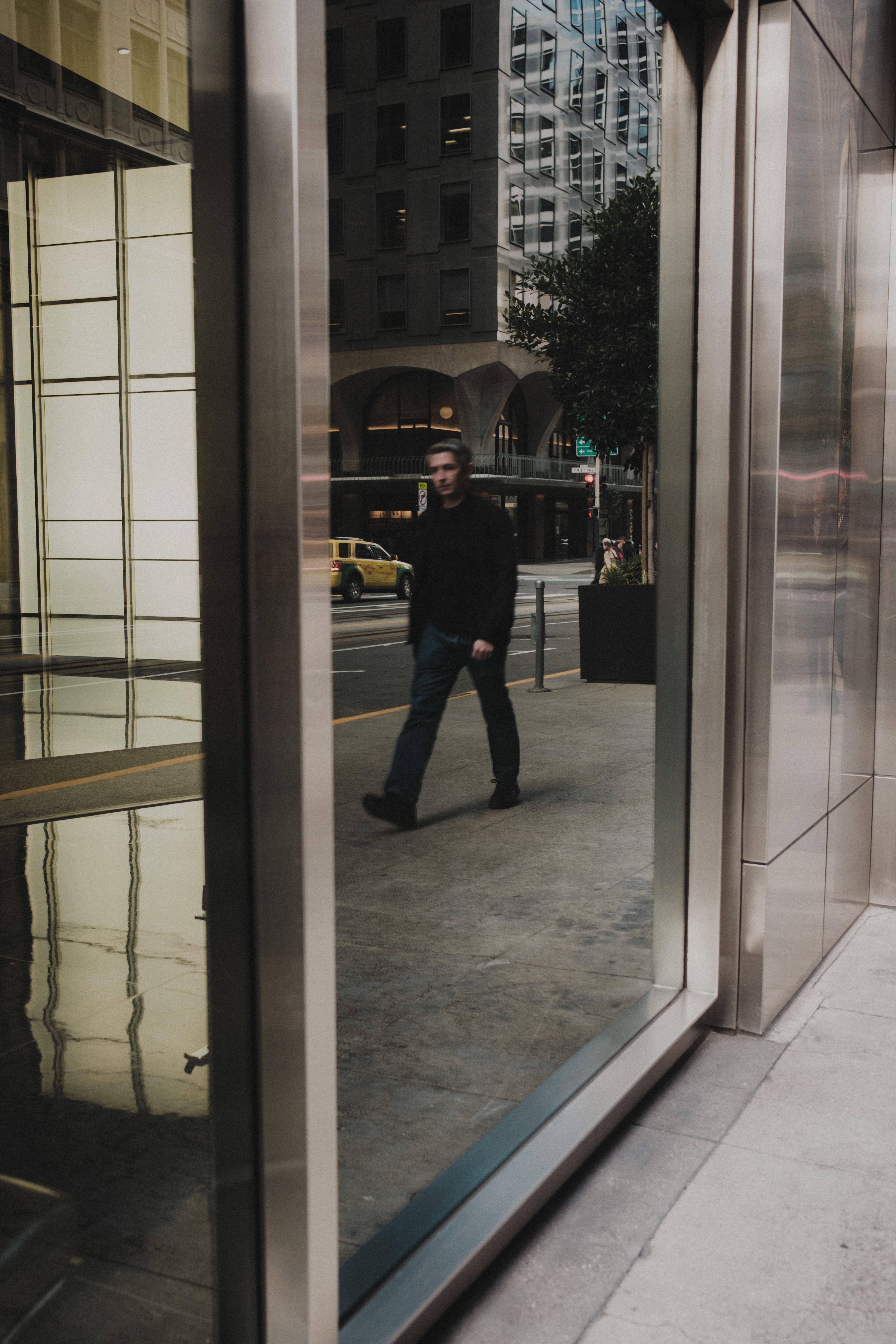 A man walking through a glass door · Free Stock Photo