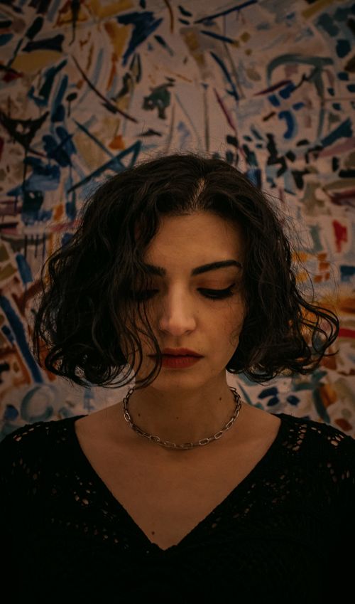 Free Moody portrait of a woman against a colorful abstract mural in Ankara, Türkiye. Stock Photo