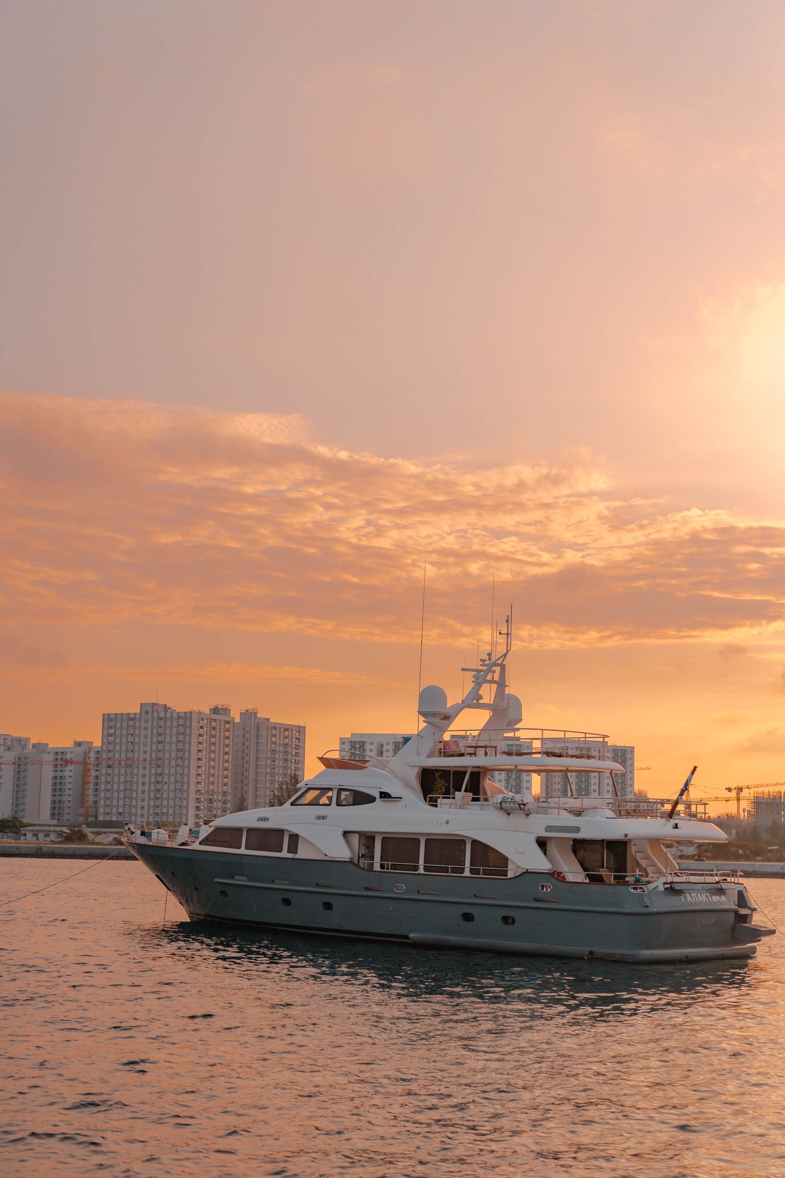 Sailing yacht with the city skyline behind it at sunset