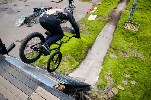 Free BMX rider skillfully descends a ramp in an urban park setting in Bogotá. Stock Photo