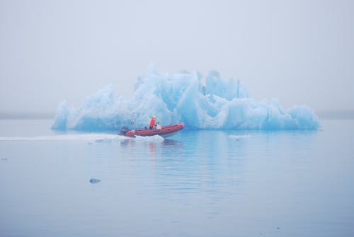 Man Sailing next to Ice Berg