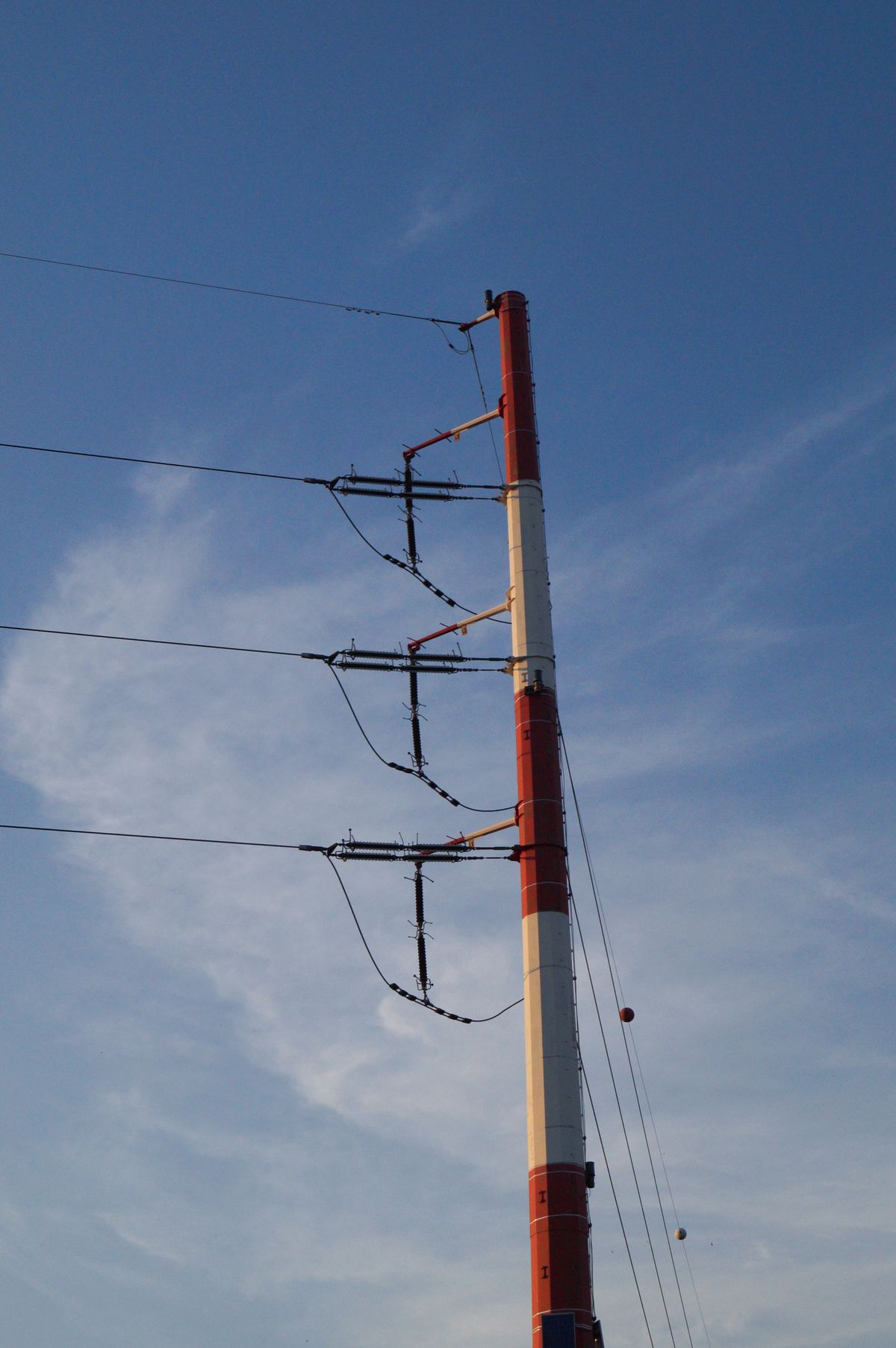 Tall power line tower against a clear blue sky, part of the Bulk Electric System covered by NERC audit evidence