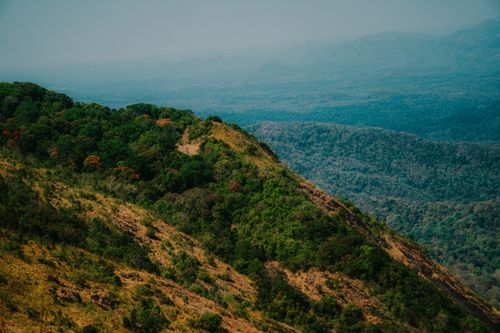 Free Captivating aerial photograph capturing the vibrant greenery and rolling hills of a mountain landscape. Stock Photo