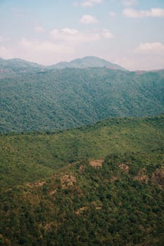 A stunning aerial shot capturing lush, green mountain ranges under a blue sky.