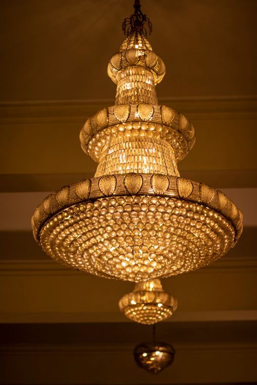 Free A luxurious golden chandelier dangling elegantly in an indoor setting, casting a warm glow. Stock Photo