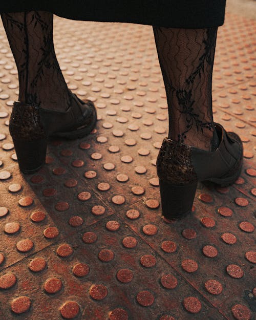 Shoes of Woman Standing on Pavement