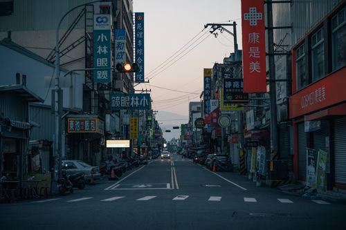 Free A vibrant city street at dusk featuring vehicles and Asian signage, offering an urban feel. Stock Photo
