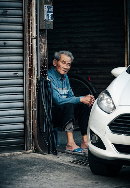 Man Sitting near Car