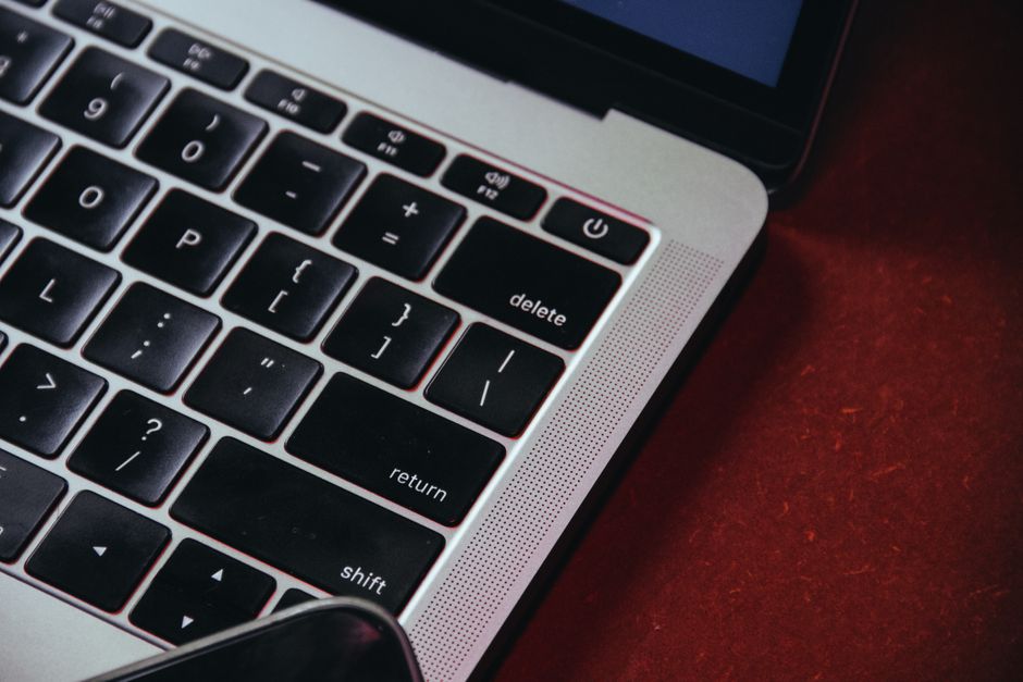 Proton Mail vs Tutanota: End-to-End Encryption Faceoff Detailed shot of a laptop keyboard highlighting black keys and a red background.