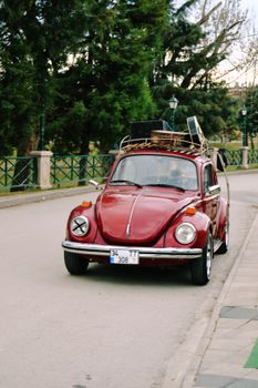 A classic red Volkswagen Beetle parked on an urban street, showcasing vintage charm.