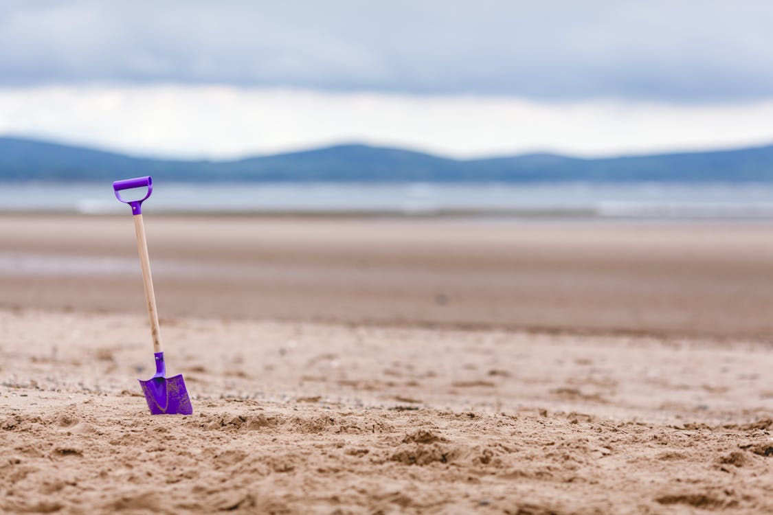Bezpłatne Purple Shovel On Sand Bottom Focus Camera Zdjęcie z galerii