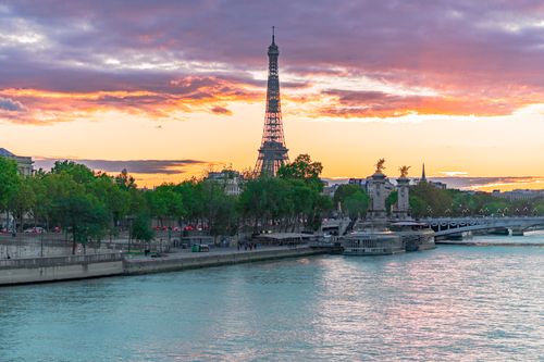 Free Stunning view of the Eiffel Tower during sunset with the Seine River reflecting the vibrant sky. Stock Photo