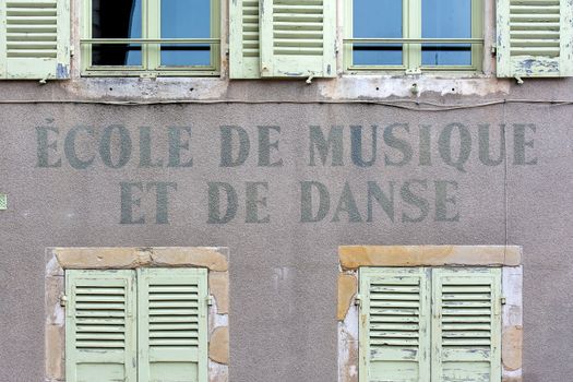 Facade of a French music and dance school with classic shutters and signage.