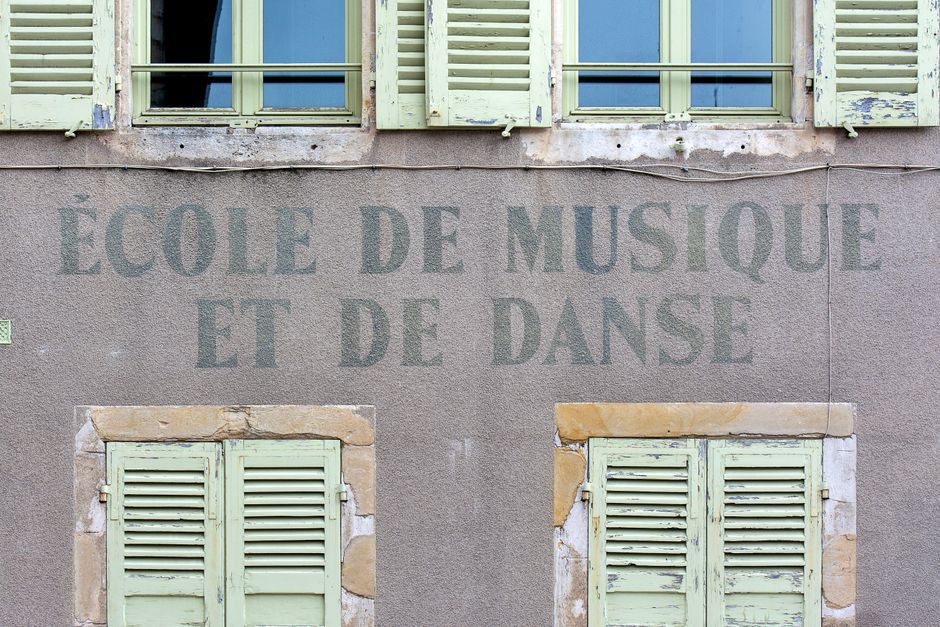 Facade of a French music and dance school with classic shutters and signage.