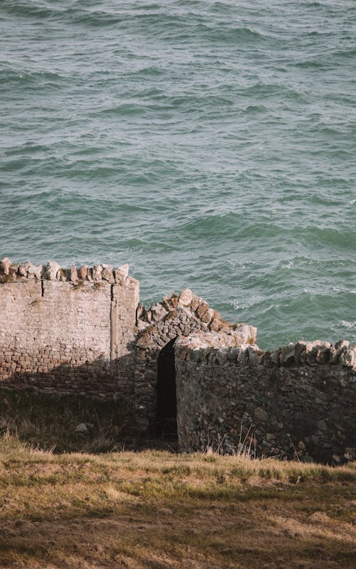 Free Old Stone Wall on Seashore on Sunset Stock Photo