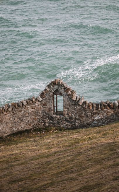 A scenic view of a historic stone wall by the sea along Dublin's picturesque coastline.
