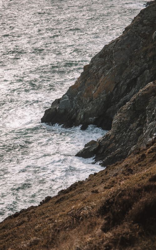 Free Serene view of rocky cliffs and sea at sunset near Dublin, Ireland. Stock Photo