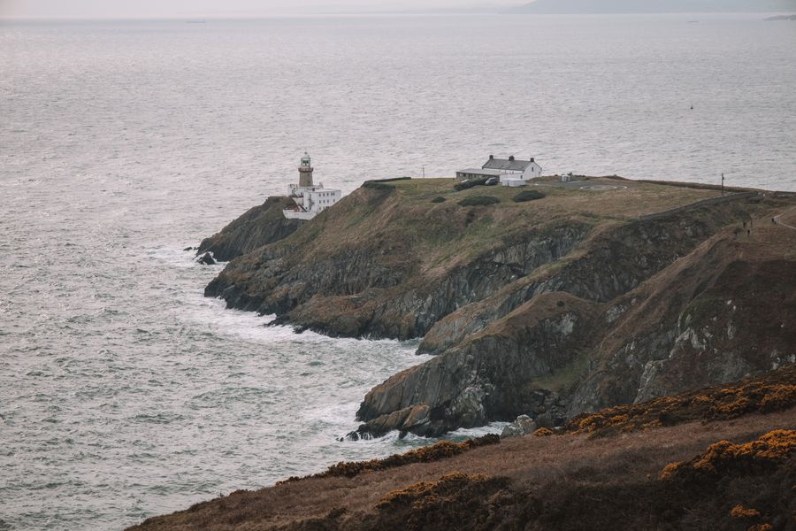 Coastal view of Baily Lighthouse on Howth Head, Dublin, Ireland. cliffs meet the vast sea