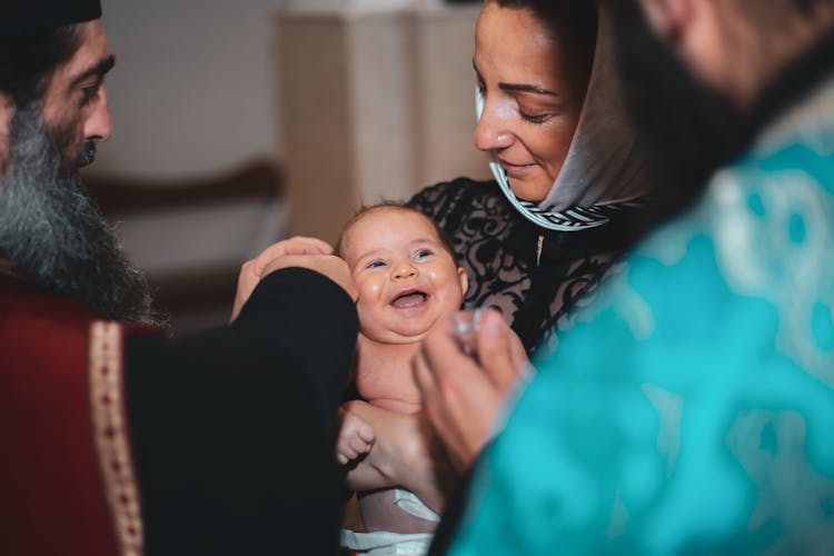 Priest Christening Newborn Baby In Church