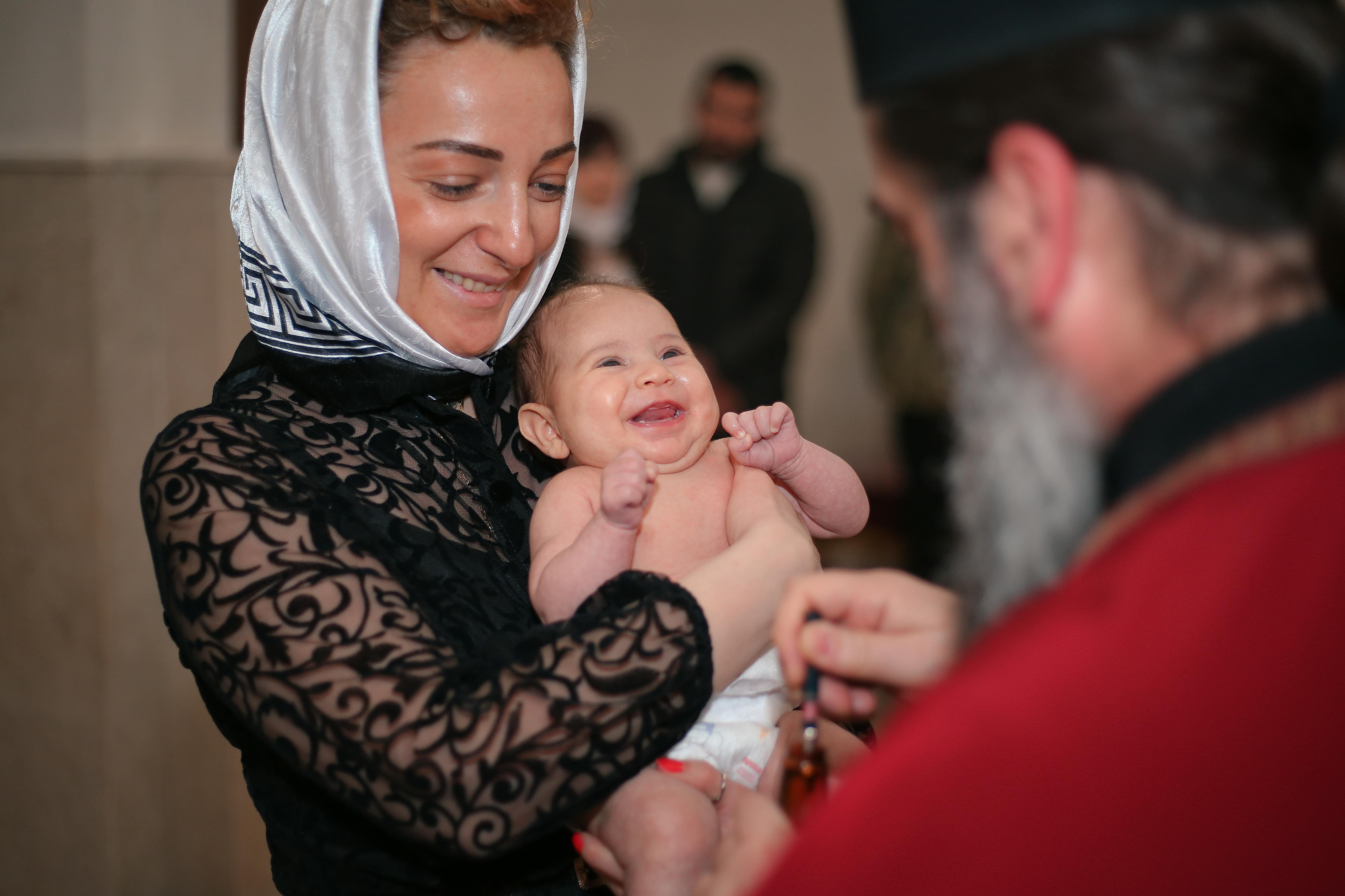 Mother Holding Her Baby during Baptism · Free Stock Photo