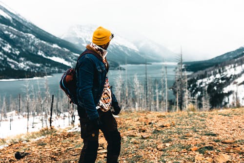 Man in Jacket Hiking near River in Winter