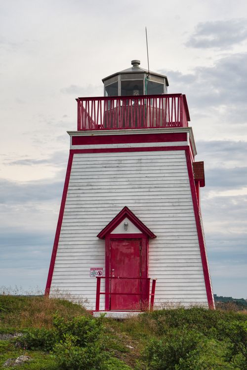 Free Charming red and white lighthouse in Trinity, Newfoundland, on a cloudy day. Stock Photo