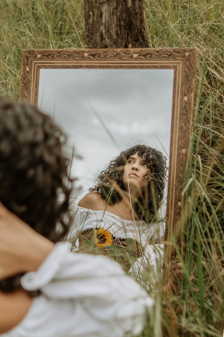 Woman Reflecting In A Mirror On The Meadow