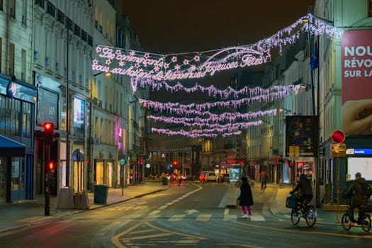 Illuminated streets of Paris during the festive season with cyclists and pedestrians under holiday lights.