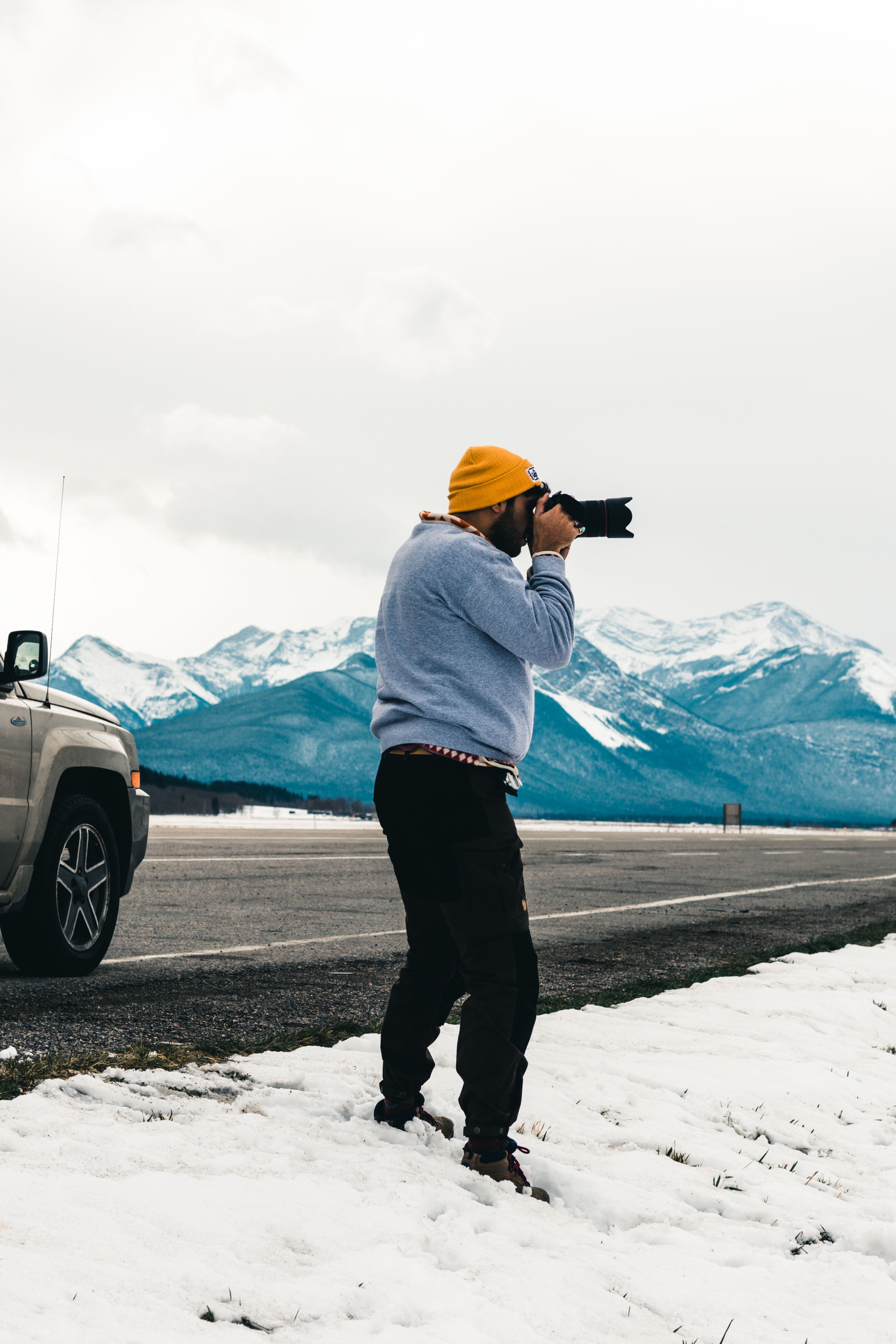 A man photographs the snowy mountains of Kananaskis, AB, Canada.