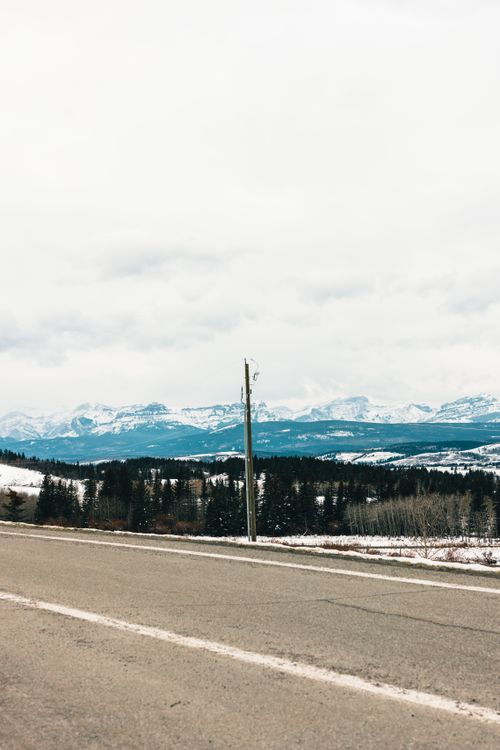 Free A tranquil winter landscape with mountains and a quiet road in Kananaskis, Alberta, Canada. Stock Photo