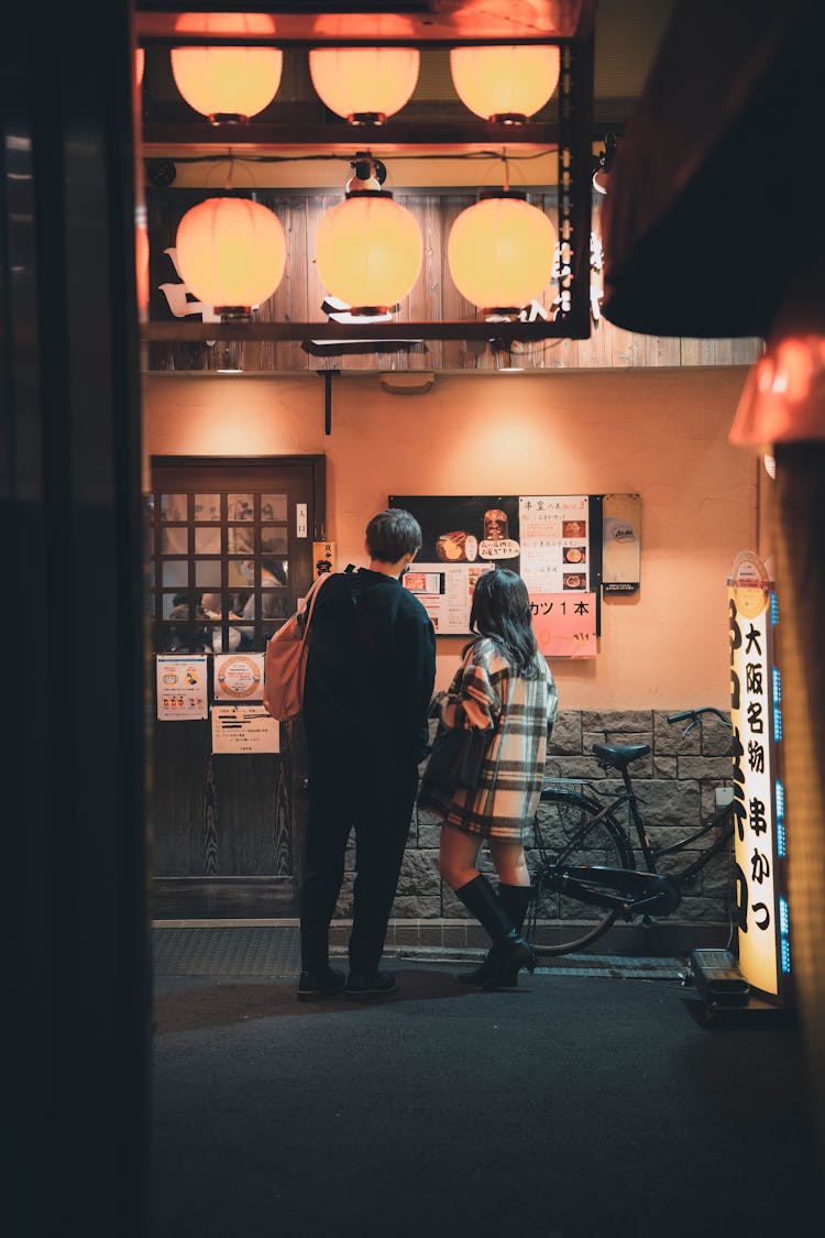 Couple Reading Menu Of Restaurant